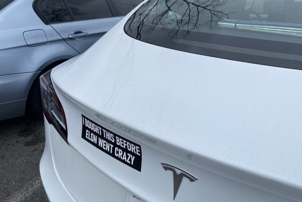 Tesla drivers express their conflicting feelings amid Elon Musk controversy with bumper stickers.  Photo by Stephanie Uchida